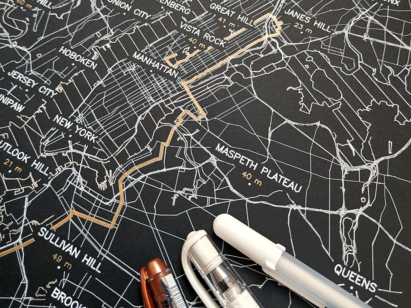 Les stylos de l'atelier posés sur une affiche fraîchement tracée